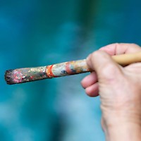 Malkurs mit unterschiedlichen Materialien Hand hält Pinsel