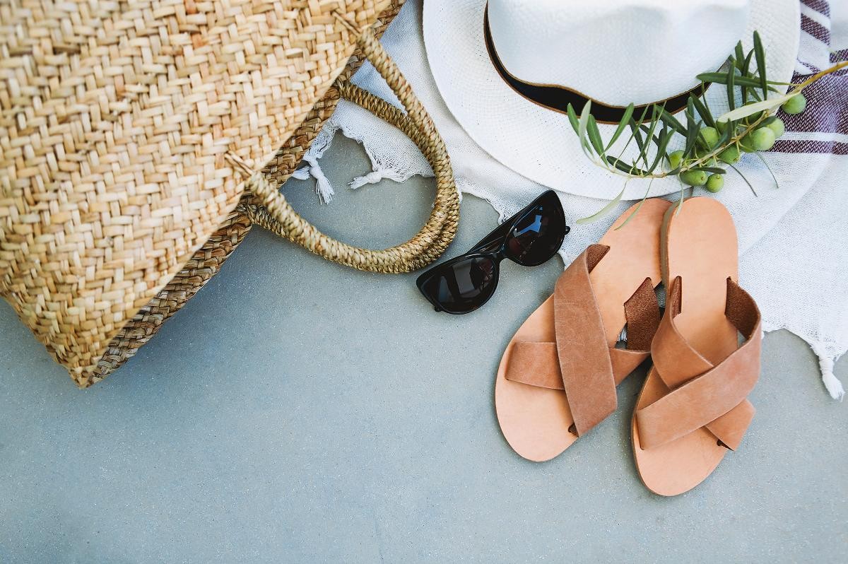 Ferienutensilien: Sonnenbrille, Sonnenhut und Strandtasche